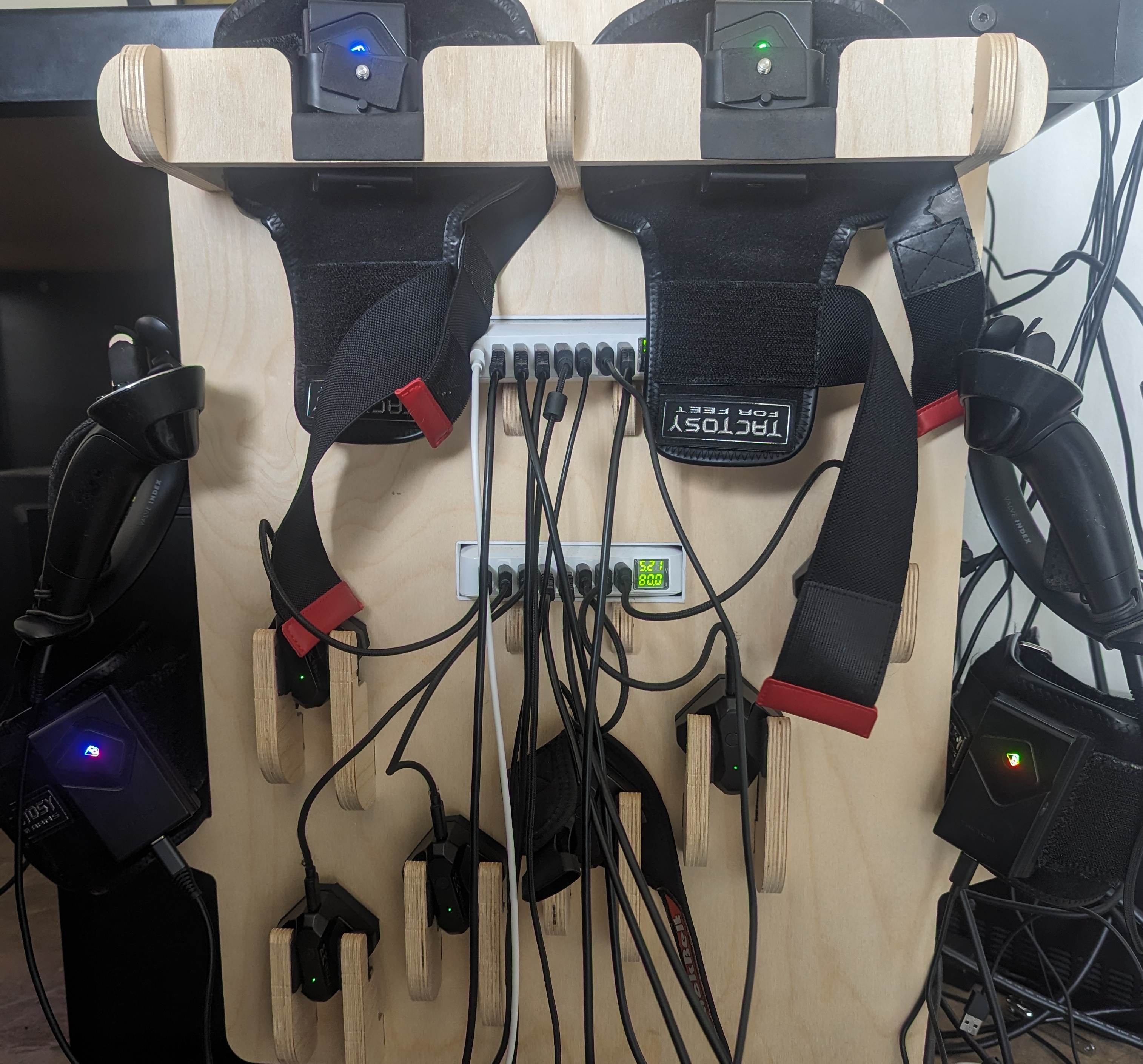 A wooden charging rack holding many VR devices